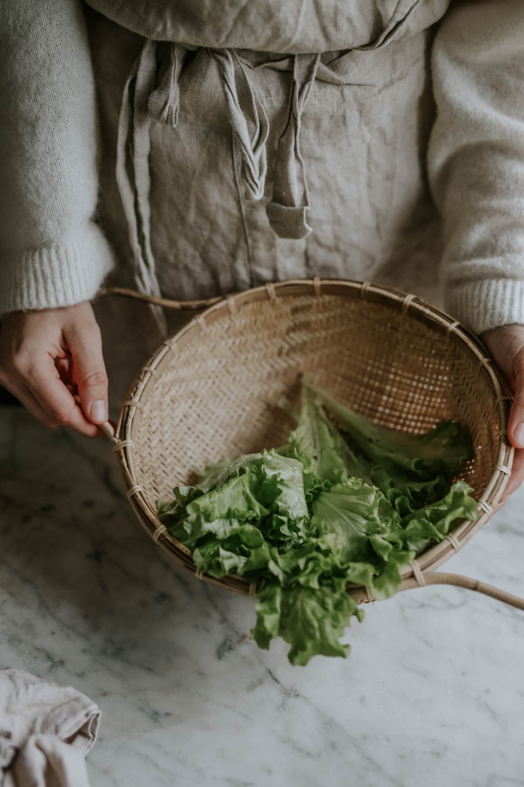 Anna kubel håller upp en korg fylld med sallad